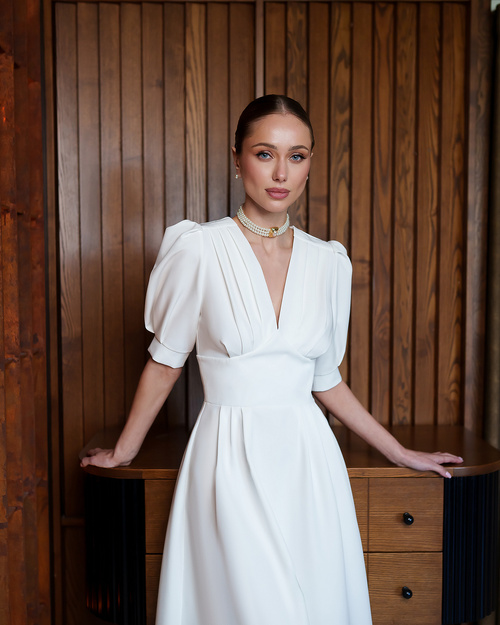 Weißes, ausgestelltes Midikleid mit kurzen Puffärmeln.